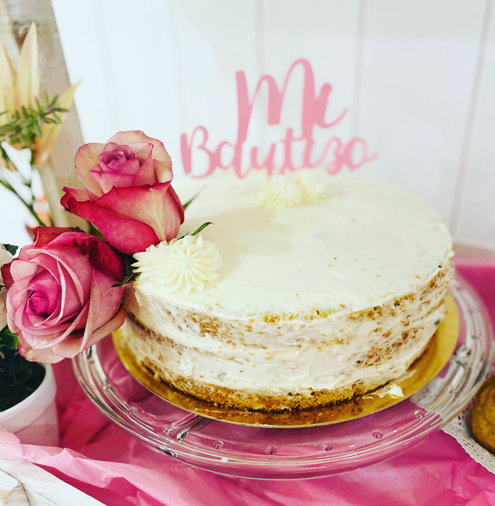 Pastel decorado con rosas y un letrero que pone "mi Bautizo"